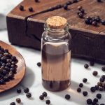 Black pepper essential oil on marble table