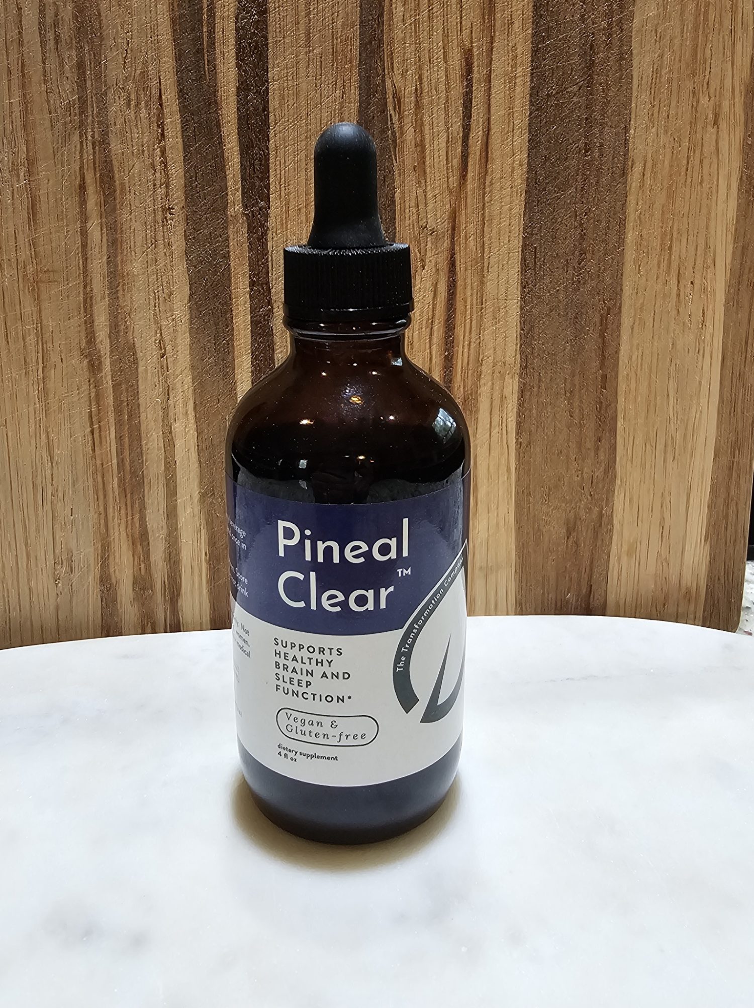 Dropper bottle of Pineal Clear supplement on table.