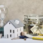 Model house with keys, cash jar, calculator
