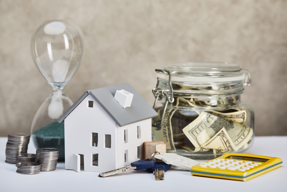 Model house with keys, cash jar, calculator